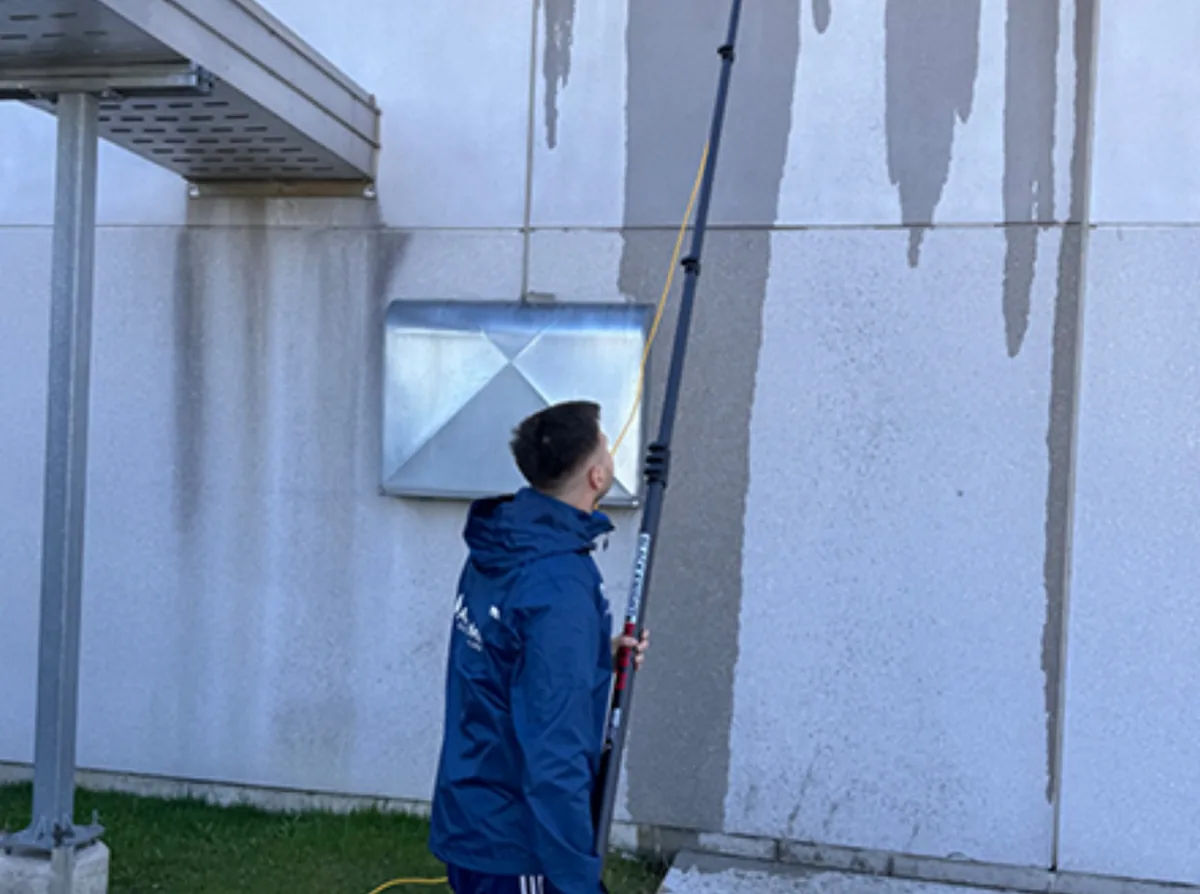 AmberMount crew member washing an exterior wall with a water-fed pole
