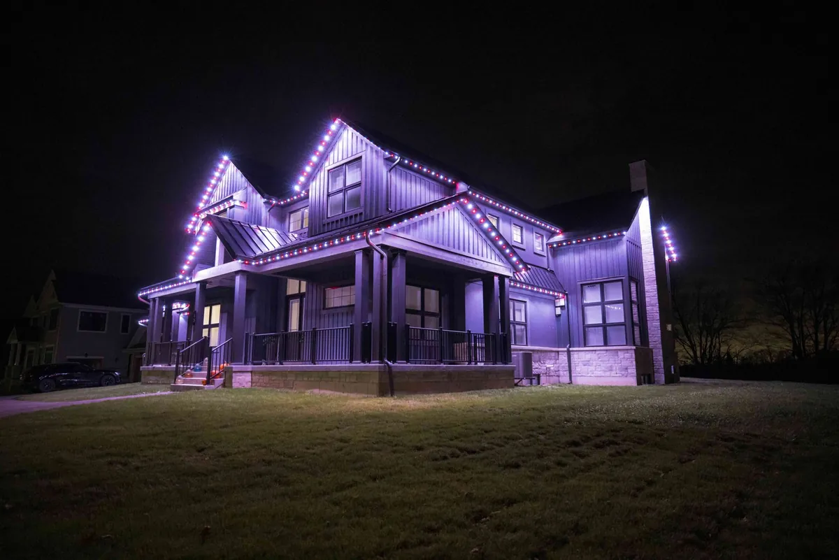 Permanent roofline lighting in purple on a modern farmhouse