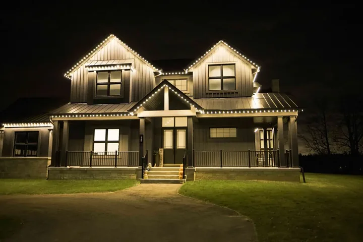 A GTA home with warm white roofline lights at night, installed by AmberMount